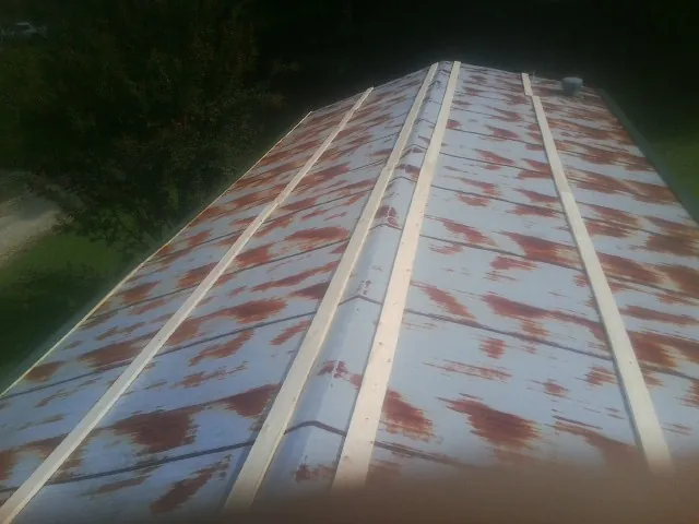 Rusted metal roof panels with new wood purlins before replacement — Storm Damage Roof Repair in New Marshfield by Roofing Brothers