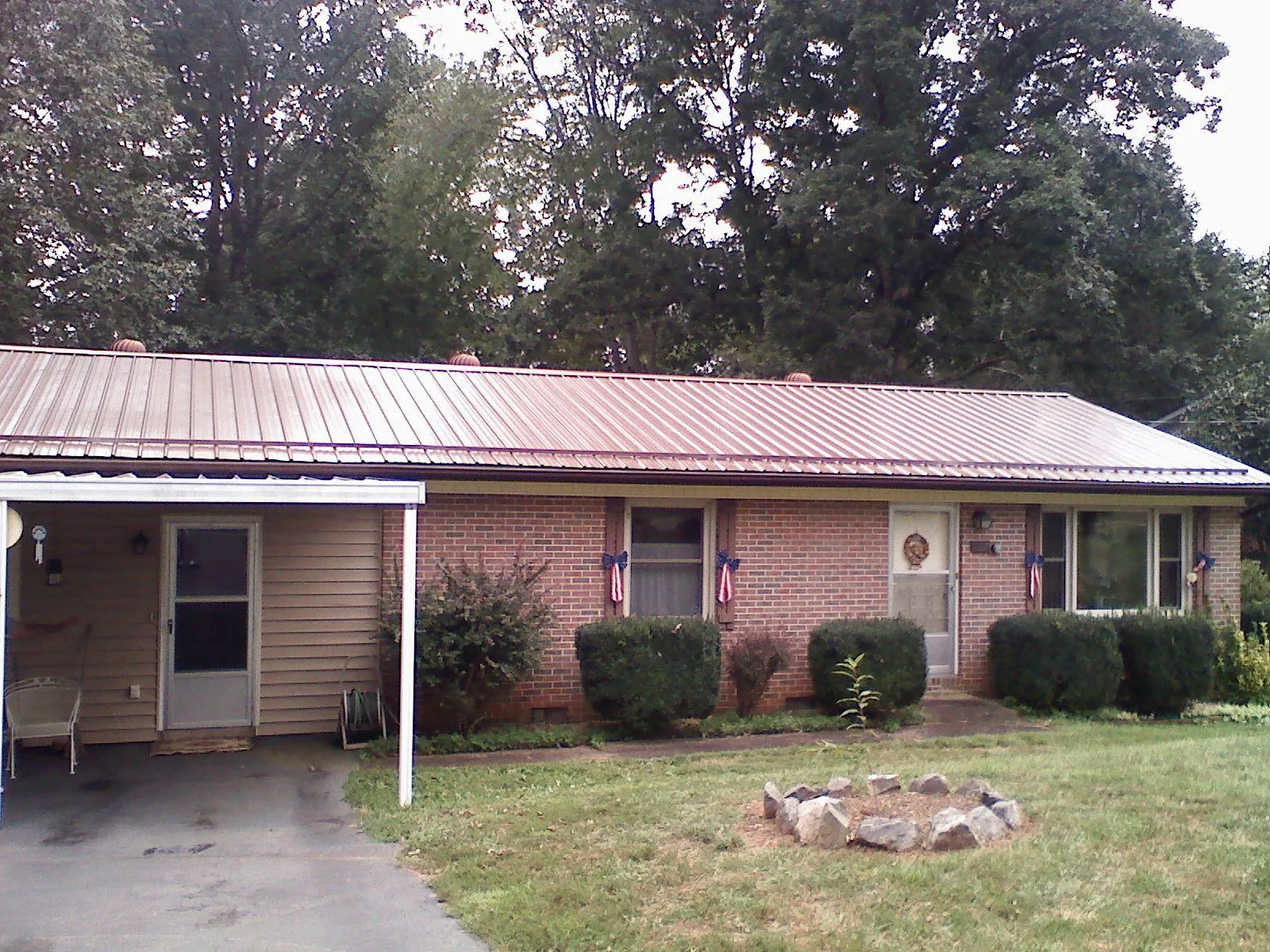 Bronze metal roof and carport on a brick ranch home — Roof Repair work by our crew in New Marshfield